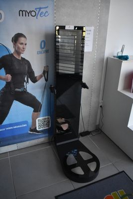 une photo d'une femme debout devant un appareil de musculation