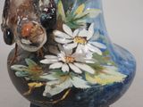 a blue vase with a bird and flowers painted on it