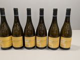 six bouteilles de vin sont alignées sur une table