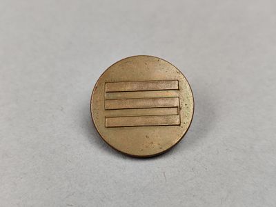un gros plan d'un petit bouton métallique sur une surface blanche