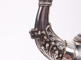 a silver vase with a bird on top of it