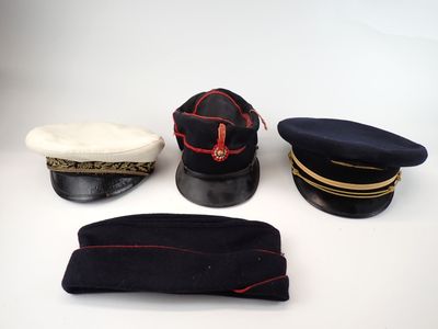 three hats and a hat cap are sitting on a white surface