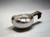 a silver teapot with a wooden handle on a table