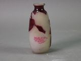 a small bottle with a red and white design on it