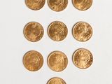several gold coins are arranged in a triangle on a white surface