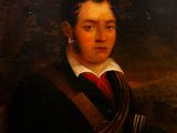 portrait d'un homme vêtu d'un manteau noir et d'une cravate rouge, tenant une pipe