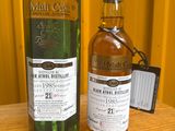 une bouteille de whisky posée sur une table, à côté d'une boîte