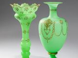 deux vases en verre vert ornés de motifs dorés, posés sur une table