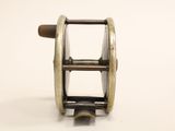 a metal reel with a wooden handle on a white surface