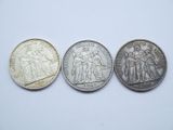 three different british coins, one silver and one silver