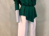 the mannequin is wearing a green top and white pants
