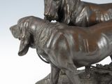 a bronze statue of a dog and a dog on a rock