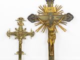 a gold cross and a bronze crucifix in a room