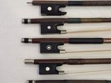 several different types of violin bows are lined up on a white surface