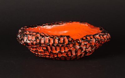 an orange bowl with black and white designs on it