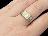 someone is holding a gold ring with a white diamond in it