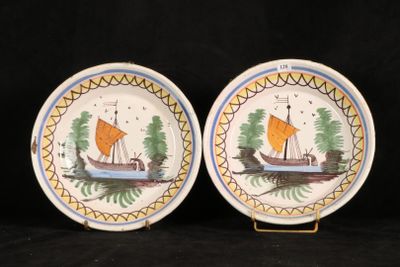 two plates with boats painted on them on a black background