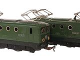 two green trains sitting next to each other on the tracks