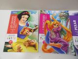 two disney princess books on a table with a mouse and a mouse