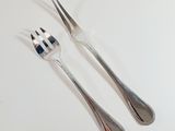 two forks and two spoons on a white table