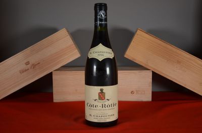 a bottle of wine sitting on a table next to a wooden box