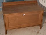 un banc en bois sur lequel est posée une pancarte, dans une pièce