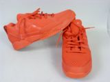 a pair of orange tennis shoes on a white surface
