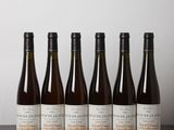 six bouteilles de vin sont alignées sur une table
