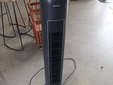 a black tower fan sitting on the floor in a room