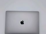 an apple macbook is sitting on top of a white table