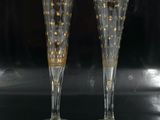 two champagne flutes with gold stars on them on a table