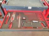 a red tool box with tools in it on a table