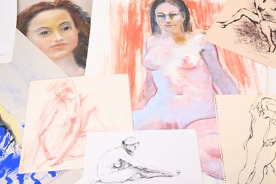 de nombreux dessins aux couleurs variées représentant une femme assise à une table