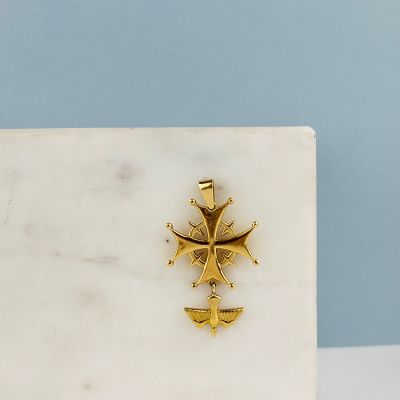 un gros plan d'une croix en or posée sur un bloc de marbre blanc