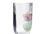 a glass vase with a flower in it on a white surface