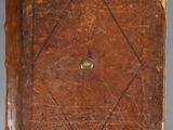 an old leather book with rivets and rivets sitting on a table
