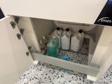 a sink that has a lot of bottles of cleaning products in it