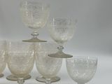 seven wine glasses sitting on top of each other on a table