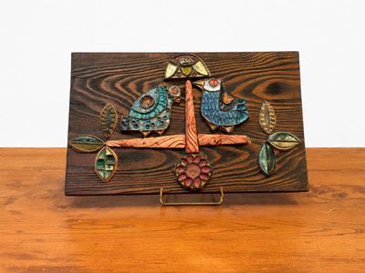 une photo d'une plaque en bois sur laquelle figurent un oiseau et des fleurs