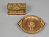 une boîte en or et une petite boîte en or posées sur une table