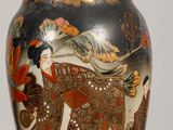 a vase with a painting on it on a table