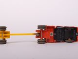 a red toy truck pulling a yellow toy car