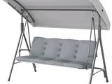 the swing chair is white and has a canopy over it