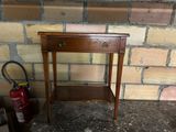 a small wooden table with a drawer on top of it