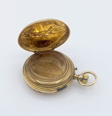 une petite montre de poche en or contenant une clé