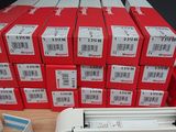a stack of red boxes and a printer on a table