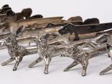 a row of silver figurines of animals on a white surface