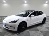 La Tesla Model 3 blanche est garée sur un sol à damier