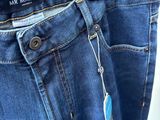 a pair of blue jeans hanging on a hanger