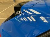 a close up of a blue car parked in a parking lot